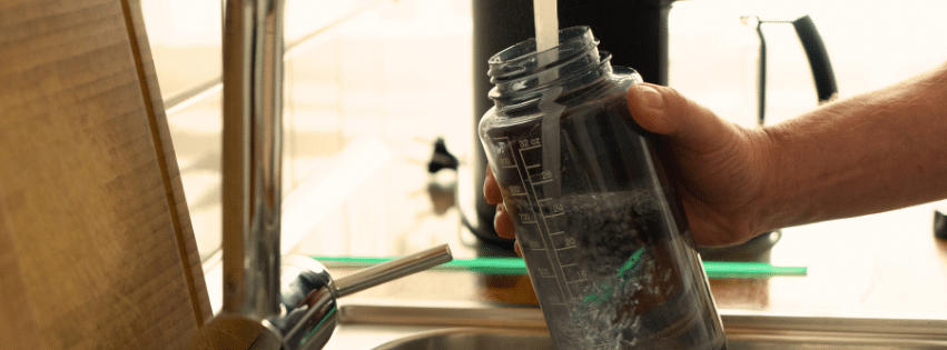 Children preparing reusable water bottles for an outdoor family adventure.